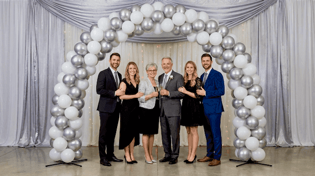 Silver and white balloon arch as photo wall at festive 25th wedding anniversary celebration