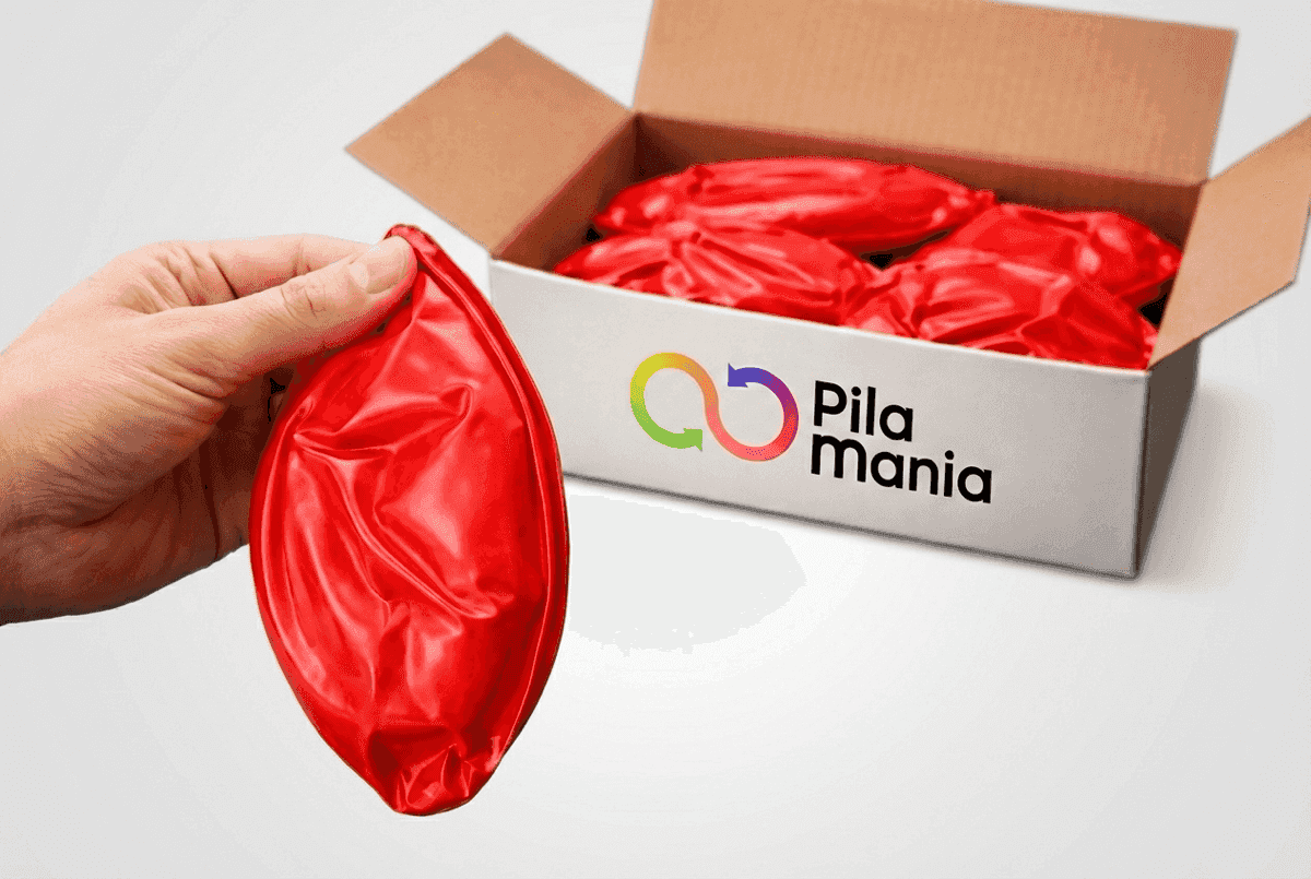 Käsi pitää tyhjää PVC-palloa laatikon yläpuolella, jossa on useita litteitä palloja